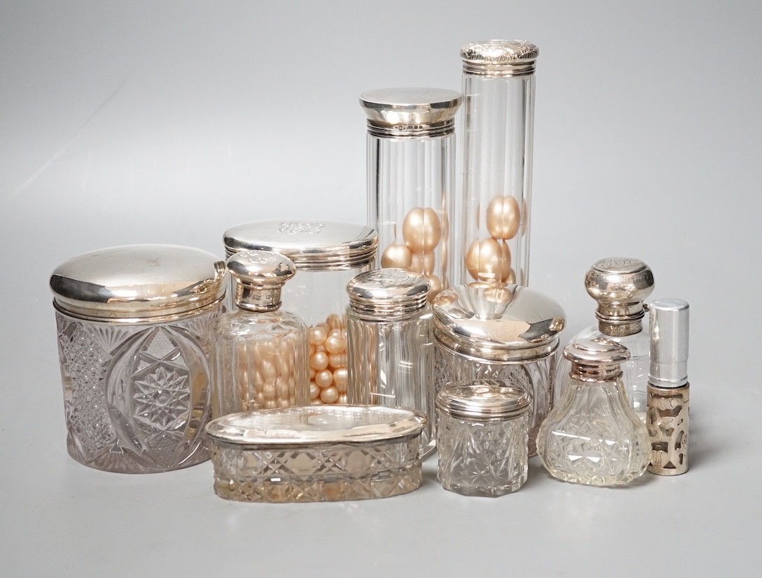 A group of assorted silver topped glass toilet bottles and a scent bottle.